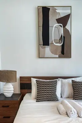 a bedroom with a bed with a picture on the wall at ShoresInn - A sublime stay in Dubai Marina in Dubai