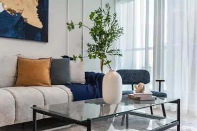 a living room with a couch and a glass coffee table at ShoresInn - A sublime stay in Dubai Marina in Dubai