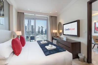 a hotel room with a bed and a flat screen tv at Downtown Elegance - 1BR Apartment with Unmatched Burj Khalifa Views in Dubai