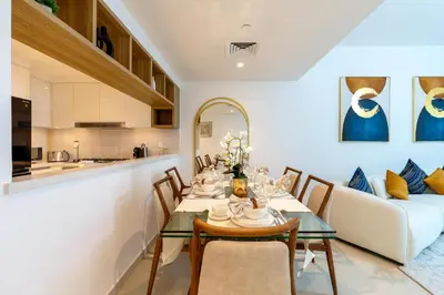 a dining room with a table and a couch at 3 Bedroom - Burj Khalifa View, Downtown Views II in Dubai