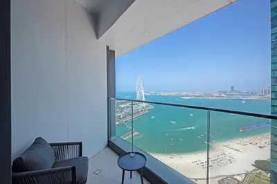 a room with a balcony with a view of the ocean at Exceptional high floor 3bed apartment by Suiteable in Dubai