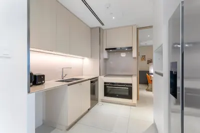 a white kitchen with a sink and a stove at Exceptional high floor 3bed apartment by Suiteable in Dubai