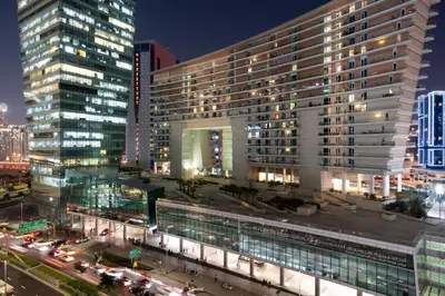 a large building in a city at night at Stunning Waterfront Burj Views with Pool & Gym, Sleeps 6 in Dubai