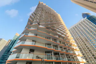 a tall apartment building with a pyramid facade at Stunning Waterfront Burj Views with Pool & Gym, Sleeps 6 in Dubai