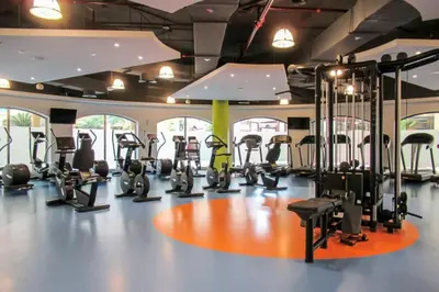 a gym with several treadmills and elliptical machines at TWIN BED-ROOM Sadaf Community near TRAM in Dubai