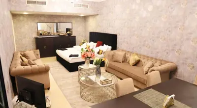 a living room with a couch and a television at Luxury Apartment by oima leasing property in Dubai