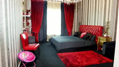 a bedroom with a bed and a red chair at Royal Classic by oima leasing property in Dubai