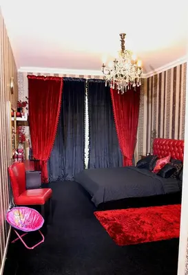 a bedroom with red curtains and a bed and a chandelier at Royal Classic by oima leasing property in Dubai