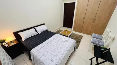 a bedroom with a bed and a wooden door at Decent Room with Balcony Near Mall of the Emirates in Dubai