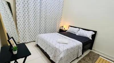 a bedroom with a bed and a table with a night stand at Decent Room with Balcony Near Mall of the Emirates in Dubai