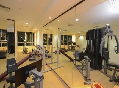 a gym with mirrors and equipment in a building at Decent Room with Balcony Near Mall of the Emirates in Dubai