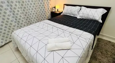 a bedroom with a bed with a black and white comforter at Decent Room with Balcony Near Mall of the Emirates in Dubai