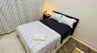 a bedroom with a bed with white sheets and pillows at Decent Room with Balcony Near Mall of the Emirates in Dubai