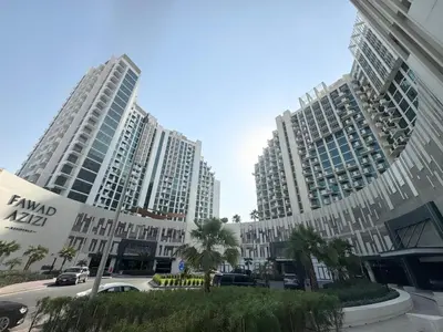 two tall buildings with palm trees in front of them at Creek view studio deleguest in Dubai