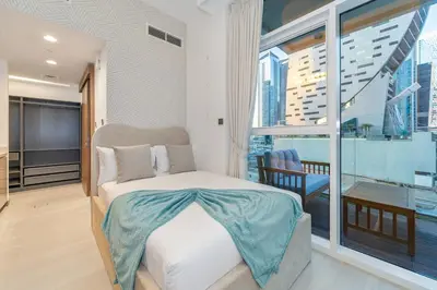 a bedroom with a bed and a large window at Charm Studio Fully Furnished with Style in Dubai