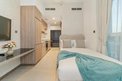 a hotel room with a bed and a television at Charm Studio Fully Furnished with Style in Dubai