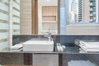 a bathroom with a sink and a counter with towels at Charm Studio Fully Furnished with Style in Dubai