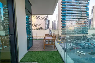 a balcony with a chair and a view of a city at Charm Studio Fully Furnished with Style in Dubai