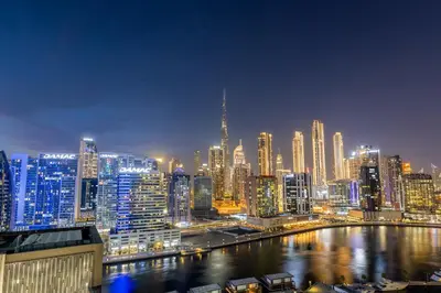 a view of a large city at night at Waves - Spacious 2BR Apartment with Burj Views & Terrace in Dubai