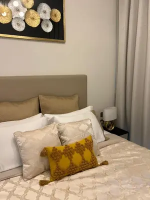 a bedroom with a bed with a yellow pillow on it at 2 Bedrooms - District One Residences 13 in Dubai