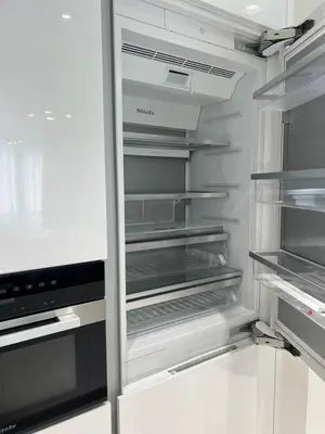 an empty refrigerator with its door open in a kitchen at 2 Bedrooms - District One Residences 13 in Dubai