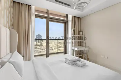 a bedroom with a bed and a large window at Stonetree - Spacious 2BR in Paramount in Dubai