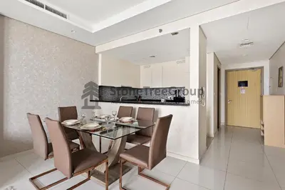 a dining room with a glass table and chairs at Stonetree - Spacious 2BR in Paramount in Dubai