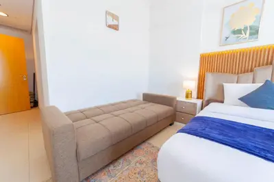 a bedroom with a bed and a couch at An Elegant Fully Furnished 1 Bedroom Apartment in Clayton Residency, Business Bay, Dubai in Dubai