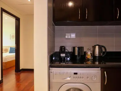 a kitchen with a stove top oven next to a counter at Waterfront 2BR Apartment with Sea Views in Dubai