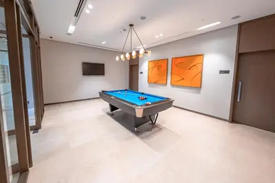 a pool table in a room with paintings on the wall at Grande Signature Residence, Burj Khalifa and Fountain View in Dubai