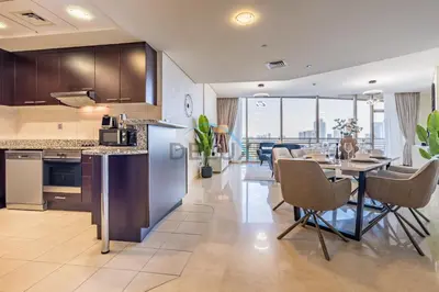 a kitchen and dining room with a table and chairs at Elegant 2BR in Sky Gardens DIFC by Deluxe Holiday Homes in Dubai