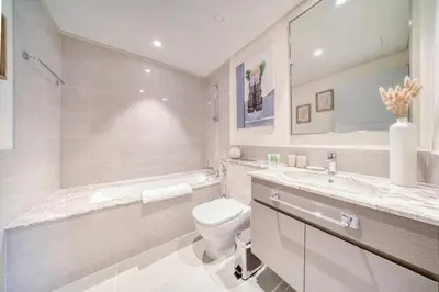 a bathroom with a toilet and a tub and a sink at Forte 2, Downtown Dubai - Mint Stay in Dubai