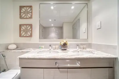 a bathroom with two sinks and a large mirror at Forte 2, Downtown Dubai - Mint Stay in Dubai