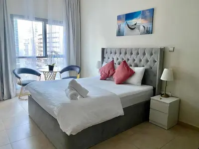 a bedroom with a large bed with red pillows at Studio in Dubai Marina by beach & Metro - Z313 in Dubai