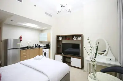 a living room with a television and a kitchen at Studio in Dubai Marina by beach & Metro - Z313 in Dubai