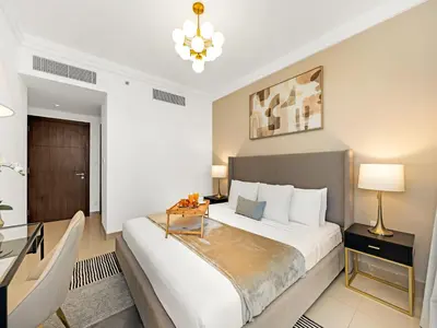 a bedroom with a large bed and a desk at Kensington Stylish 1BR at The Lofts East Downtown in Dubai