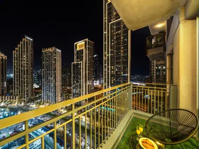 a balcony with a view of the city at night at Kensington Chic 1BR Fountain-view Flat Downtown Burj Khalifa in Dubai