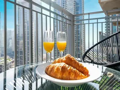 a plate of bread and two glasses of orange juice at Kensington Chic 1BR Fountain-view Flat Downtown Burj Khalifa in Dubai