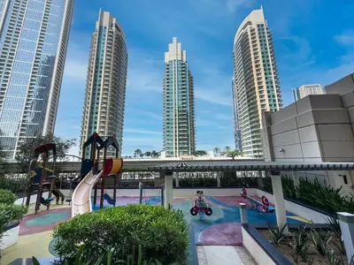 a playground in a city with tall buildings at Kensington Chic 1BR Fountain-view Flat Downtown Burj Khalifa in Dubai