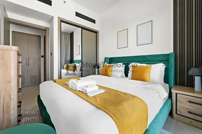 a bedroom with a large bed with a green headboard at High-Floor and Spacious 1BR at Binghatti Emerald in Dubai