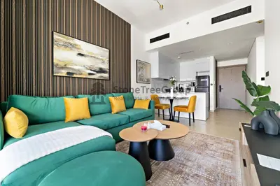 a living room with a green couch and a table at High-Floor and Spacious 1BR at Binghatti Emerald in Dubai