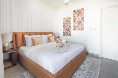 a bedroom with a large bed with a table on it at Frank Porter - Ranches 3 in Dubai