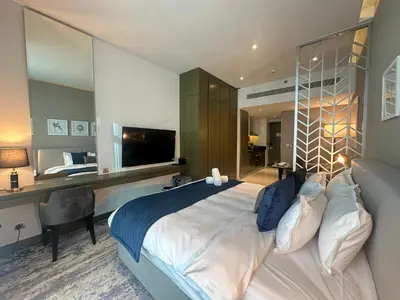 a bedroom with a bed and a desk and a television at Business Bay Modern studio with a Pool view at DAMAC Maison Prive in Dubai