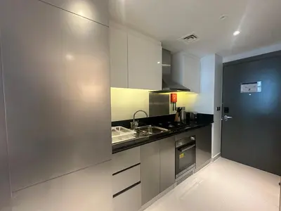 a kitchen with white cabinets and a sink at Business Bay Modern studio with a Pool view at DAMAC Maison Prive in Dubai