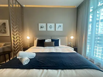 a bedroom with a large bed with towels on it at Business Bay Modern studio with a Pool view at DAMAC Maison Prive in Dubai