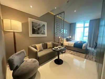 a living room with a couch and a bed at Business Bay Modern studio with a Pool view at DAMAC Maison Prive in Dubai