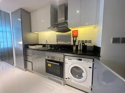 a kitchen with a washing machine and a washer at Business Bay Modern studio with a Pool view at DAMAC Maison Prive in Dubai