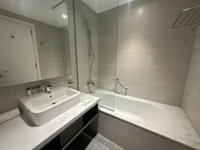 a white bathroom with a sink and a shower at Business Bay Modern studio with a Pool view at DAMAC Maison Prive in Dubai