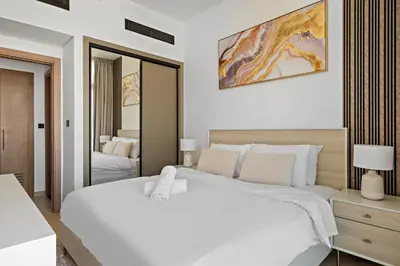 a bedroom with a large white bed and a mirror at Modern and High Floor 1BR at Binghatti Emerald in Dubai