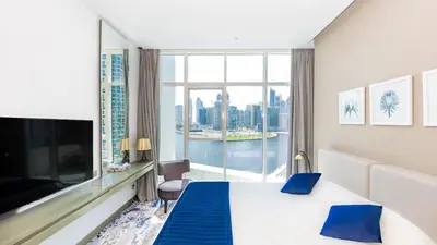 a hotel room with a bed and a large window at Conveniently Located Apartment With Waterfront View in Dubai
